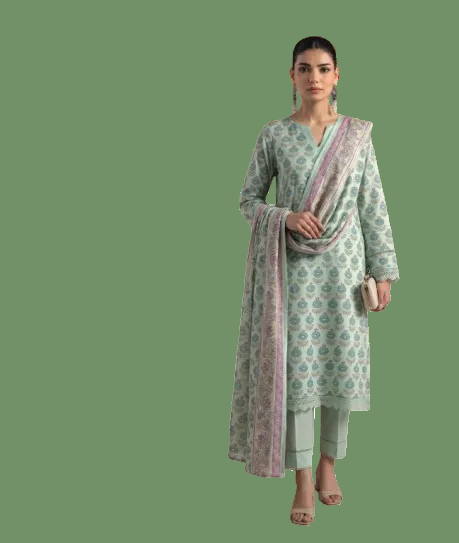 A woman modeling a mint green three-piece traditional outfit with a floral block print and a matching dupatta featuring a pink border, set against a plain white background.